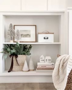 a white shelf filled with books and vases on top of it's shelves