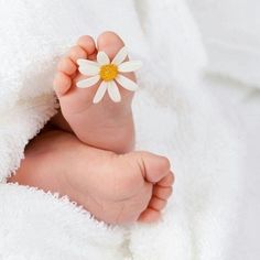 a close up of a baby's foot with a flower on it