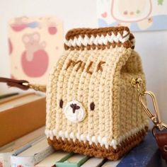 a crocheted bear purse sitting on top of a table next to a cup