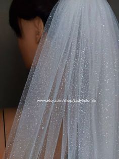 the back of a bride's wedding veil with white glitters on it,