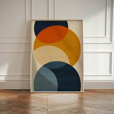 an abstract art piece is displayed in front of a white wall with wood flooring