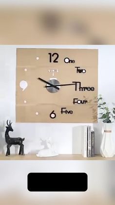 a wooden clock on the wall in front of a book shelf with two deer figurines