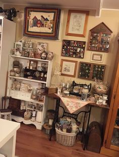 a room filled with lots of different items and pictures on the wall above it is a sewing machine