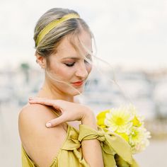 a woman in a yellow dress holding a flower