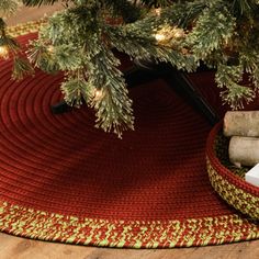 a christmas tree skirt is on the floor next to a pile of firewood and presents