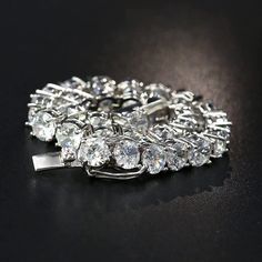 a close up of a brooch on a black surface with lots of diamonds in it