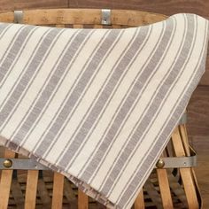 a striped blanket sitting on top of a wooden chair