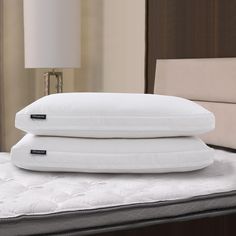 two pillows stacked on top of each other on a bed