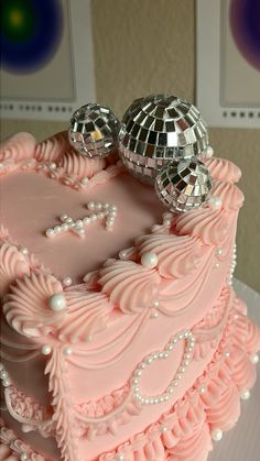 a pink cake with disco balls on top