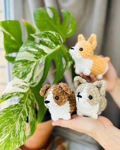 three small crocheted animals sitting next to a plant