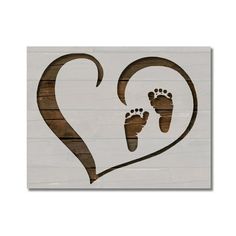 a wooden sign with two footprints in the shape of a heart and a baby's foot