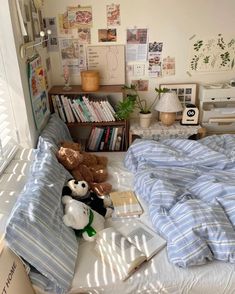 there is a bed with blue and white comforter in the room next to bookshelves