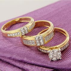 two gold rings with diamonds on purple cloth