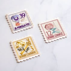 four different stamps with flowers on them sitting on a counter top next to each other