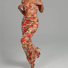 a woman in floral print pants and crop top posing for the camera with her hands on her hips