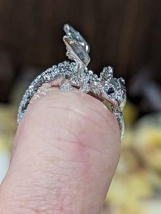 Introducing our adorable adjustable baby dragon fashion ring, the perfect accessory for any occasion! Crafted with attention to detail, this elegant piece features an intricate design that wraps around your finger, adding a touch of sophistication to your look. Treat yourself or surprise a loved one with this timeless accessory that is sure to add a unique twist to your everyday style. Order yours today and elevate your jewelry collection to new heights! This handcrafted ring is sealed to preven Elegant Adjustable Dragon Design Jewelry, Elegant Adjustable Jewelry With Dragon Design, Adjustable Sterling Silver Dragon Jewelry, Adjustable Sterling Silver Jewelry With Dragon Design, Unique Adjustable Dragon Design Jewelry, Adjustable Unique Jewelry With Dragon Design, Dragon Design Ring Jewelry Gift, Dragon Design Ring Jewelry For Gift, Adjustable Dragon Design Ring