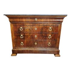 an antique chest of drawers with marble top and brass pulls on the front, against a white background