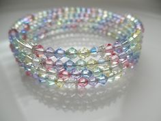 "\"GLAMOROUS!\" Pastel Rainbow Crystal Memory Wire Bracelet with Silver Accent ONE SIZE FITS MOST Composition: Premium top-of-the-line European crystals in soft pastel-colored bicone crystals of light yellow, light green(AB), light blue, light pink, light purple and clear AB accentuated by interspersed silver daisy spacers. 2.5\" diameter stainless steel memory wire It wraps around the wrist 4 times and will retain it's slinky shape. Easy on - easy off! The bracelet ends are looped. This item wi Bracelet Ends, Memory Wire Jewelry, Bracelet For Her, Wire Bracelets, Spring Bracelet, Memory Wire Bracelet, Beaded Wrap Bracelets, Memory Wire Bracelets, Crystal Beads Bracelet