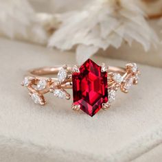 a close up of a ring with a red stone in the middle and white diamonds around it