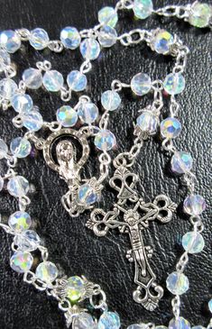 "This Catholic rosary is made of clear Aurora Borealis crystals. It is a complete 5 decades and a good gift for First Communion or a Baptism. The body is 26\" around and the cross drop is 5 inches. The rosary will be slipped into a velvet bag and shipped in a bubble mailer." Silver Beaded Rosary For First Communion, Silver Rosary Bracelet With Round Beads For Baptism, Silver Faceted Beads Rosary Cross, Silver Spiritual Rosary Bracelet For First Communion, Silver Rosary With Faceted Beads For Gift, Silver Rosary With Faceted Beads As Gift, Adjustable Silver Rosary With Faceted Beads, Silver Baptism Jewelry With 8mm Beads, Silver Rosary With Faceted Beads