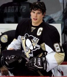 a hockey player sitting in the bench with his helmet on