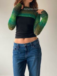 a woman in jeans and a black top is posing with her hands on her hips