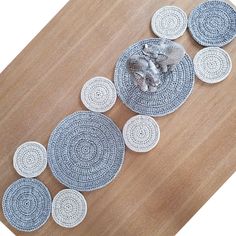 several decorative plates on a wooden table with an elephant figurine in the middle