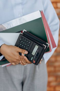 a person holding a calculator and folders