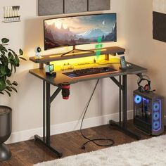 a computer desk with a monitor and keyboard on it in front of a wall mounted plant