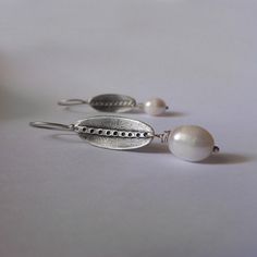 Minimal and elegant white freshwater pearl earrings. These handmade earrings are made from 925 sterling silver, with modern, minimal contemporary design and satin finish are great for everyday wear, but for special occasions also! Great gift for bridesmaids, mother's day or for an anniversary. ► DESCRIPTIONS and MEASUREMENTS: Handmade from 925 sterling silver The black area is oxidized to create contrast in the design. The line sanded to a satin, matte contrast. Pearl size: 18 x 10 mm Oval measu Handmade Minimalist White Pearl Earrings, Handmade White Minimalist Pearl Earrings, Minimalist Handmade White Pearl Earrings, Silver Oval Pearl Earrings For Pierced Ears, Nickel-free Pearl White Sterling Silver Earrings, Silver Oval Pearl Drop Earrings, White Sterling Silver Pearl Earrings For Anniversary, Oval Sterling Silver Pearl Earrings, Oval White Pearl Earrings