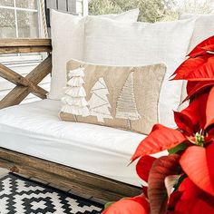 a white couch sitting on top of a wooden floor next to a red poinsettia