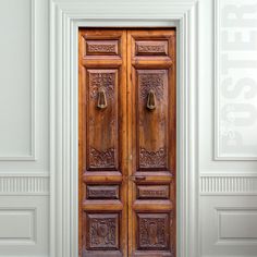 an old wooden door in a white room with two doors on either side and the floor