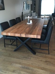 a wooden table with black leather chairs around it