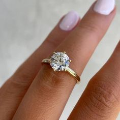 a woman's hand with a ring on it and a diamond in the middle