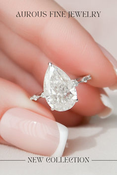 a woman's hand holding a diamond ring with the words new collection on it