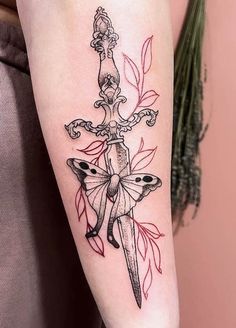 a tattoo on the arm of a woman with a knife and flowers in her hair