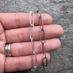 I make these elongated cable chains entirely by hand from pure sterling silver. I form, solder, and texture each link one at a time. I then make handmade hook clasps to finish the chains. This chain is available with either 2 handmade hook clasps (one on each end) or 1 handmade hook & eye clasp. Be sure to see all photos and video for size and finish reference.Select your desired clasp choice, silver finish, and total necklace length when ordering. Length includes clasp(s).Each chain link measur Silver Cable Chain Link Bracelet, Silver Oval Link Chain Bracelet With Cable Detail, Silver Cable Chain Bracelet With Oval Links, Silver Oval Link Chain Bracelet Minimalist Style, Minimalist Silver Oval Link Chain Bracelet, Everyday Rolo Chain Bracelet, Sterling Silver Paperclip Bracelet With Oval Links, Silver Paperclip Chain Bracelet With Oval Links, Silver Sterling Paperclip Chain Bracelet