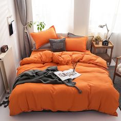 an orange comforter on a bed in a room