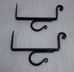 two black hooks are sitting on a white sheet