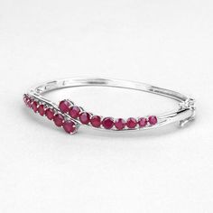 Ruby Bangle, Natural Graduated Glass-Filled Ruby Rounds Cuff Bangle Bracelet for Women, Red Gemstone Bangle, July Birthstone Bangle for HerFlaunt yourself with this glass filled ruby bangle. The natural gemstones have a combined weight of 7.48  carats and are set in .925 sterling silver with rhodium plating. The vivid red hue of this bracelet adds a pop of color to any look!  The understated design and vibrant stones makes this bracelet perfect for every occasion.♥ Benefits of wearing Ruby gemst Elegant Red Round Cuff Bracelet, Red Ruby Gemstone Bangle, Wedding Red Cuff Bracelet, Red Fine Jewelry Bangle, Red Bangle Fine Jewelry, Red Gemstone Cuff Bracelet, Red Gemstone Bangle Cuff Bracelet, Ruby Bangles, Tanzanite Bracelet