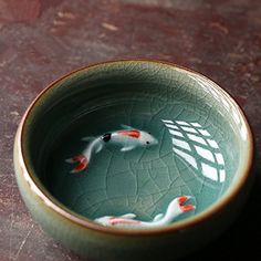 a bowl with two fish in it sitting on a table