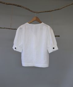 "Classic white and black women V-neck button down blouse, easy to be layered with camisole as a shirt or by itself as a blouse. The puffy sleeves are very flattering; pair it with pants, jeans or skirts for a chic and young look. - Prewashed medium weight linen (180g) - Relaxed fit - Button down opening - Elbow-length puffed sleeves with cuff and button - Can be tucked or untucked Please provide your shoulder width, full bust measurement ( measured around the fullest part) and your height in the Summer V-neck Blouse With Button Cuffs, Summer V-neck Blouse With Rolled Sleeves, White Half Sleeve Top With Button Closure, Summer V-neck Tops With Button Cuffs, White Half Sleeve Blouse With Buttons, Solid Color Relaxed Fit Puff Sleeve Top, Relaxed Fit Solid Color Puff Sleeve Top, White Short Sleeve Top With Button Cuffs, Casual Linen Puff Sleeve Tops