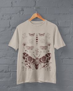 Moths and Mushrooms T-shirt Printed on a super soft, cotton tee Dispatched in 5 working days or sooner Unisex Free UK delivery Material: 100% ringspun cotton. Chest (to fit): S  34/36   M  38   L  40/42   XL  44/46   XXL  48/50 ECO-FRIENDLY Each garment is made to order, reducing extra material and energy that would be otherwise wasted We use DTG printing process which is easier on the environment than screen-printing Our ink is bright and also eco-friendly. Do not tumble dry Wash at 30 degrees Summer Fairycore Crew Neck T-shirt, Fairy Grunge Crew Neck T-shirt Relaxed Fit, Fairy Grunge Relaxed Fit Crew Neck T-shirt, Fairy Grunge Crew Neck T-shirt With Screen Print, Fairy Grunge Graphic Print Crew Neck T-shirt, Fairycore Cotton T-shirt With Graphic Print, Fairycore Graphic Print Cotton T-shirt, Goblincore Short Sleeve T-shirt For Summer, Fairy Grunge Short Sleeve Top With Screen Print