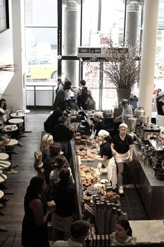 a group of people standing in front of a counter filled with food