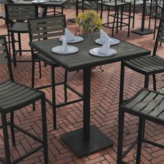 tables and chairs are set up outside on the brick floored patio with flowers in vases