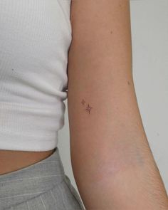 a small star tattoo on the left side of the right arm is shown in black ink