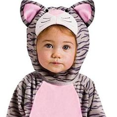 a baby in a tiger costume is wearing a pink bib and a gray cat hat