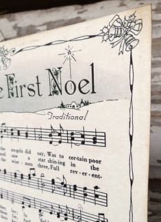 an old sheet with music notes on it that says the first noel and is hung up