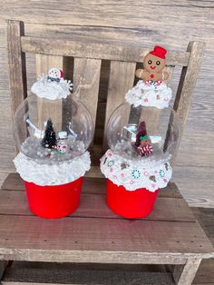 two snow globes sitting on top of a wooden chair