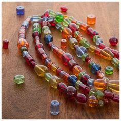 multicolored glass beads are arranged on a wooden surface